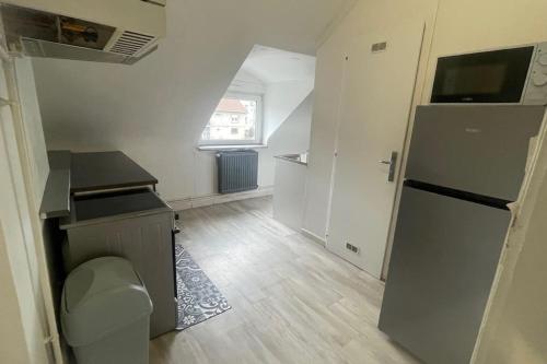 une cuisine avec un évier et un réfrigérateur dans une pièce dans l'établissement Le Petit Répit - Proche Metz Amnéville Luxembourg, à Serémange-Erzange