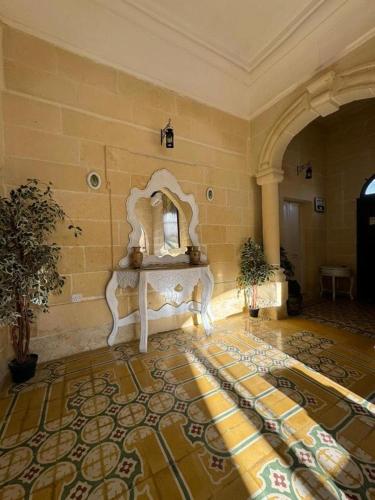 a room with a stone wall with a table and a rug at Ta Speranza Farmhouse B&B in Victoria