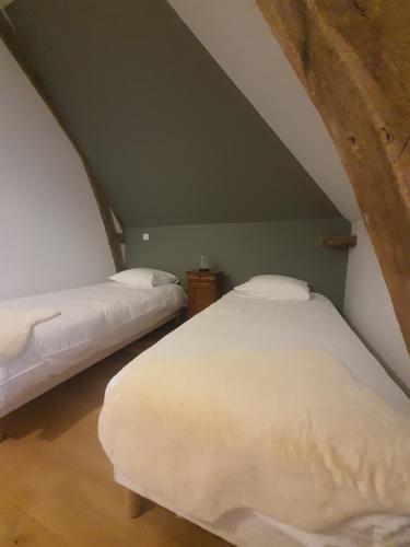 a bedroom with two beds in a attic at Le Pressoir de mon Père in Foulbec