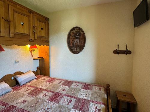 une chambre avec un lit et une horloge au mur dans l'établissement Charmant appartement, au pied des pistes, balcon - FR-1-181-2089, à La Plagne Tarentaise