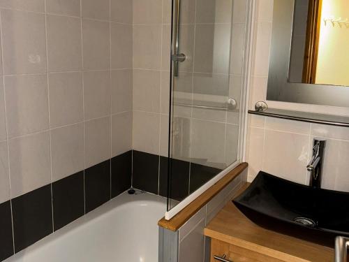 une salle de bain avec une baignoire et un lavabo dans l'établissement Charmant appartement, au pied des pistes, balcon - FR-1-181-2089, à La Plagne Tarentaise