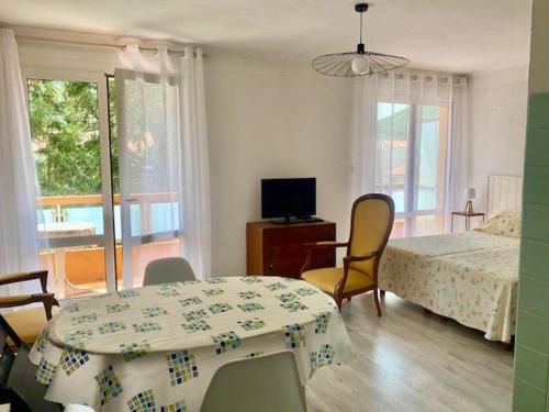 une chambre avec un lit, une table et des chaises dans l'établissement Studio lumineux avec balcon, Wi-Fi, proche des thermes d'Amélie-les-Bains - FR-1-703-52, à Amélie-les-Bains-Palalda