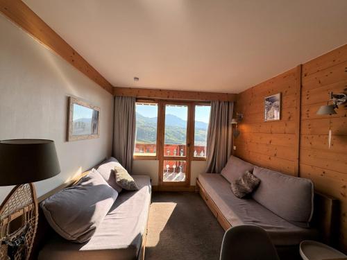 un salon avec un canapé et une fenêtre dans l'établissement Appartement 3 pièces, 7 pers, Pied des pistes, Animaux admis - FR-1-181-2038, à La Plagne Tarentaise