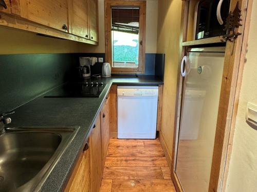 une cuisine avec un évier et un réfrigérateur blanc dans l'établissement Appartement 3 pièces, 7 pers, Pied des pistes, Animaux admis - FR-1-181-2038, à La Plagne Tarentaise