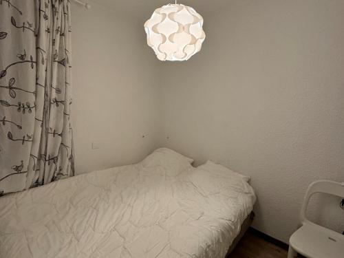 - une petite chambre avec un lit et une lumière dans l'établissement Appartement cosy au pied des pistes avec balcon et WIFI - FR-1-181-2151, à La Plagne Tarentaise