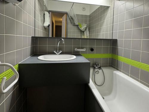 une salle de bain avec un lavabo et une baignoire dans l'établissement Appartement cosy au pied des pistes avec balcon et WIFI - FR-1-181-2151, à La Plagne Tarentaise
