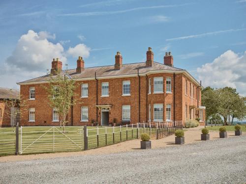 a large brick building with a fence in front of it at Constantine House in Tamworth