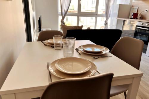 une table de salle à manger avec des assiettes et des verres dessus dans l'établissement Nancy Centre Gare Appartement rénové 3 chambres, à Nancy