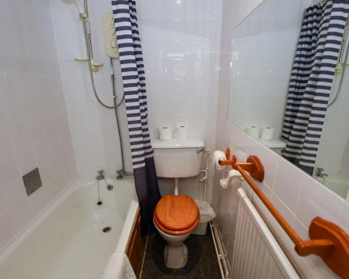 a bathroom with a toilet with a wooden toilet seat at Conwy Valley Hotel in Conwy