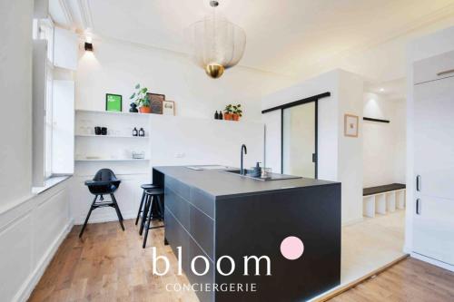 a kitchen with a black island in a room at Le Saint Georges Nancy Stanislas in Nancy