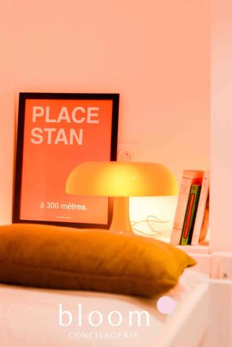 une lampe assise sur une table à côté d'un oreiller dans l'établissement Le Saint Georges Nancy Stanislas, à Nancy