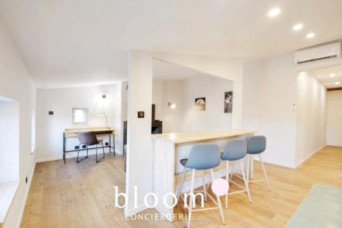 Il comprend une cuisine et un salon avec un comptoir et des chaises bleues. dans l'établissement Nancy vieille ville bel appartement rénové, à Nancy