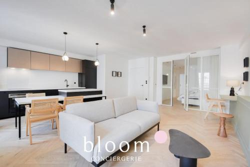 un salon avec un canapé blanc et une cuisine dans l'établissement Le Charles 3 Appartement de Standing, à Nancy