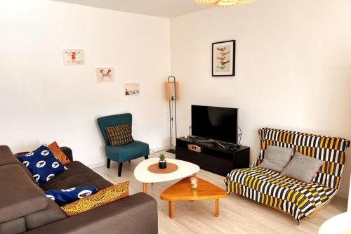 un salon avec un canapé et une télévision dans l'établissement Superbe F2 avec garage balcon, à Nancy