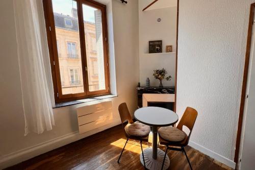 une salle à manger avec une table et des chaises et une fenêtre dans l'établissement Nancy Centre ville Studio rénové et équipé, à Nancy