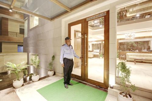 a man standing in front of a door at Marks Hotel & Banquet in Noida