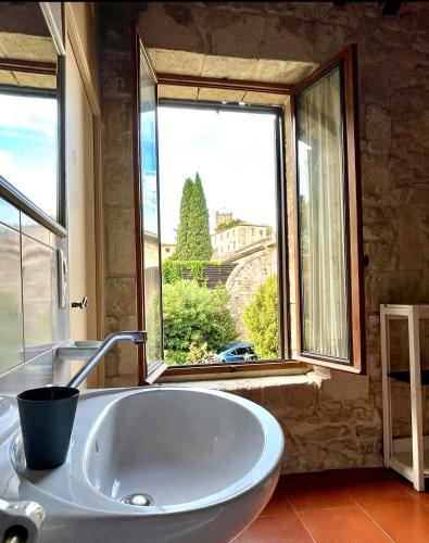 une salle de bain avec un lavabo et une grande fenêtre dans l'établissement Domaine du Mas Fontclaire Sommières - 28 pers, à Sommières