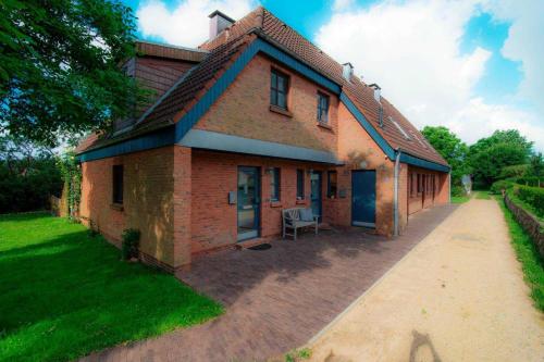 una grande casa di mattoni su un vialetto di mattoni di Austernfischer, Reihenhaus Guatingwai 12 FH 2 a Goting