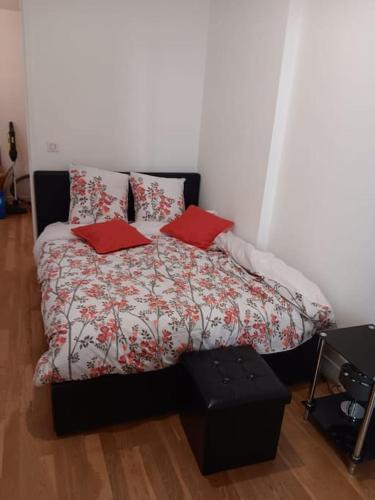 une chambre avec un lit avec deux oreillers rouges dans l'établissement La Citadine, Paris à 10 minutes par le Métro 8, à Maisons-Alfort