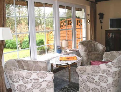 een woonkamer met 2 banken, een tafel en een raam bij Hochstieg 36, Feld, Hausteil in Nieblum