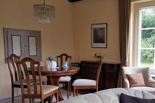 een eetkamer met een tafel en stoelen en een tafel en een raam bij Hochstieg 36, Feld, Hausteil in Nieblum