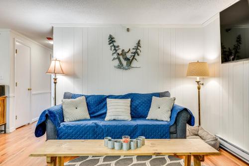 a living room with a blue couch and a table at Renovated Ski-InandSki-Out Peru Condo at Bromley Mtn in Peru