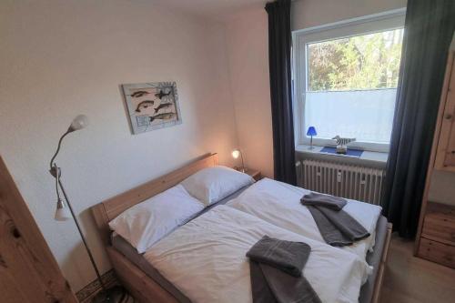 a bedroom with a bed with white sheets and a window at Haus Severin Whg Findling EG in Goting