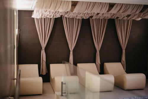 a living room with white chairs and a glass table at Grand Hotel Yerevan - Small Luxury Hotels of the World in Yerevan