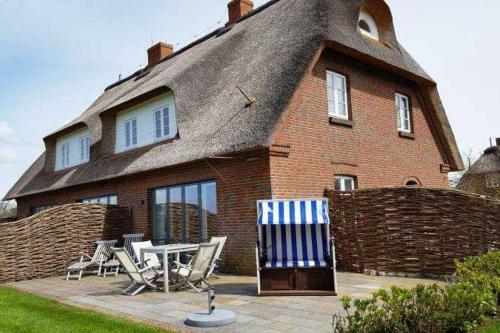 una casa con sedie e un tavolo di fronte ad essa di Hüs Saaltfeen, Hausteil Guatingwai 18 a a Goting