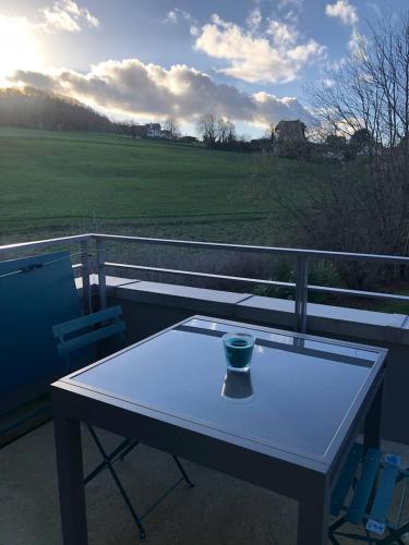 une table blanche sur un balcon avec un vase dessus dans l'établissement Havre de paix à Benerville-sur-Mer, à Benerville-sur-Mer