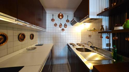 une cuisine avec un évier et un plan de travail dans l'établissement Hostdomus - Violet Apartment, à Sestrières