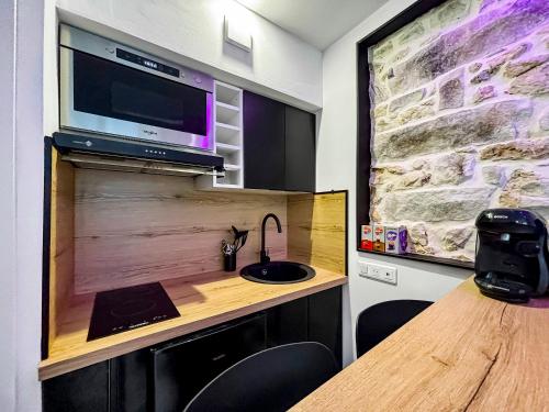 Cette chambre dispose d'un bureau, d'un lavabo et d'une télévision. dans l'établissement Studio Moderne à 5 min à pied du Château, à Fontainebleau