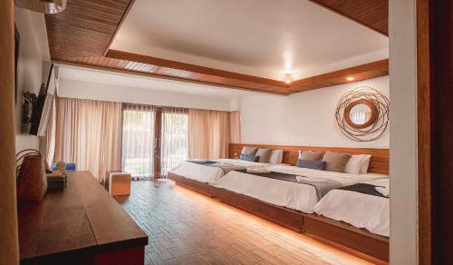 a bedroom with two beds and a large window at Sichon Cabana Beach Resort in Sichon