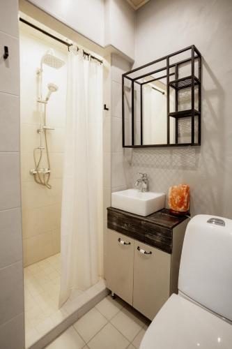 a bathroom with a sink and a toilet and a mirror at Von Aghte Small Studio in Kuressaare