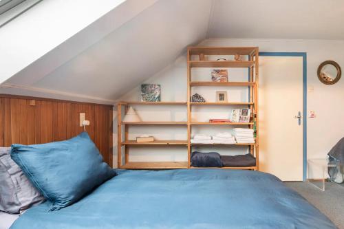 a bedroom with a blue bed and a book shelf at Cozy room in residential Alkmaar - Free parking in Alkmaar
