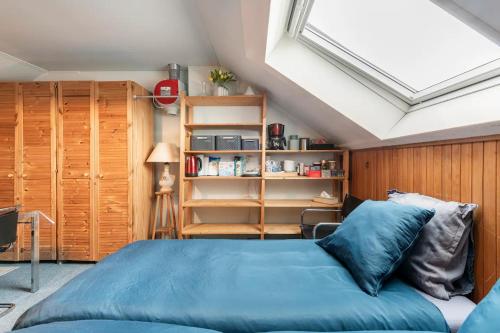 a bedroom with a blue bed and a skylight at Cozy room in residential Alkmaar - Free parking in Alkmaar