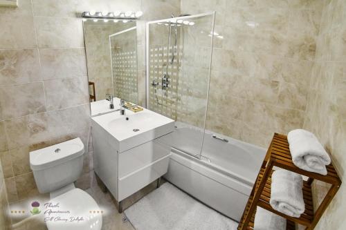 a bathroom with a tub and a sink and a toilet at Thistle Apartments - King's Apartment in Aberdeen