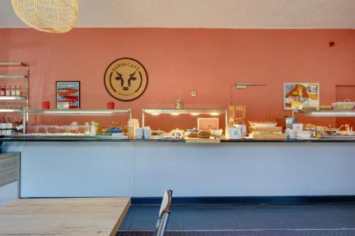 a counter in a restaurant with a clock on the wall at Sure Hotel by Best Western Annecy in Annecy