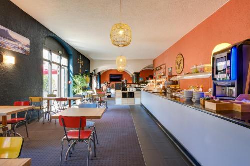 a restaurant with tables and chairs and a counter at Sure Hotel by Best Western Annecy in Annecy