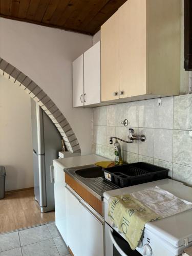 a kitchen with a sink and an archway at Vikendica S, Alibegovac in Petrovaradin
