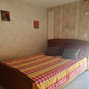 une chambre avec un lit avec une tête de lit en bois dans l'établissement Mini-studio équipé et rénové, à Balaruc-les-Bains