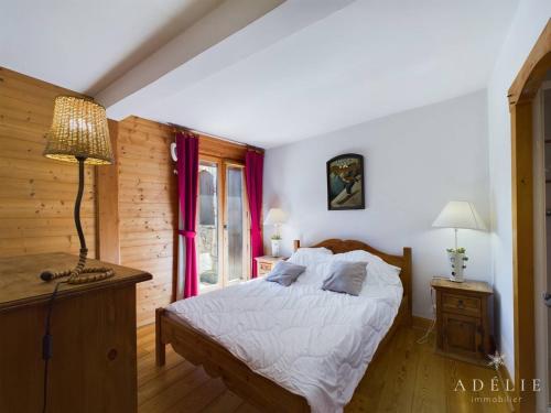 une chambre avec un lit, une lampe et une fenêtre dans l'établissement Appartement 3* avec terrasse exposée sud, proche des pistes et commerces, parking inclus - FR-1-398-535, à Montvalezan