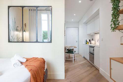Cette chambre blanche dispose d'un lit et d'une cuisine. dans l'établissement 60 HEROLD - Magnifique Studio - Terrasse - Climatise, à Nice