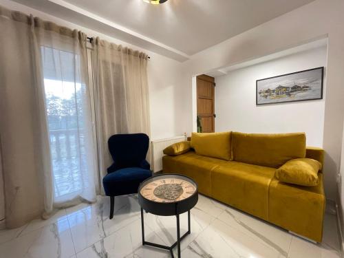 a living room with a yellow couch and a chair at House Jesenova in Selce