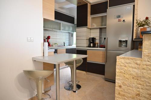 a kitchen with a table and a refrigerator at Roza’s Appartment in Durrës