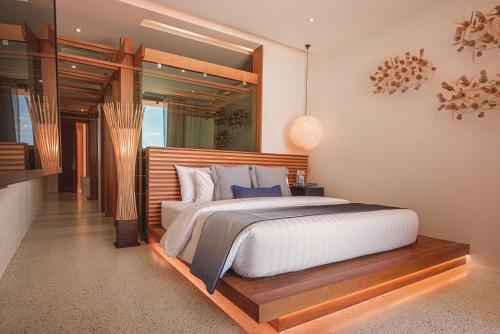 a bedroom with a large white bed and a mirror at Sichon Cabana Beach Resort in Sichon
