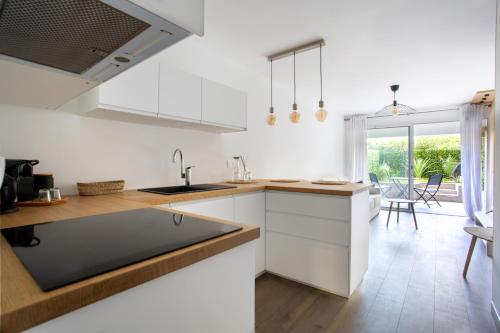une cuisine avec des placards blancs et une grande fenêtre dans l'établissement Studio cosy Marina Baie Des Anges, à Villeneuve-Loubet