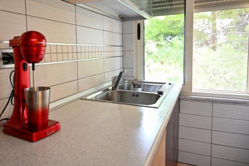 a kitchen with a sink and a red fire hydrant at Roza’s Appartment in Durrës