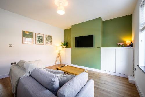a living room with a couch and a flat screen tv at Beautiful 2 Bedroom House in Atherton, Free Parking in Atherton