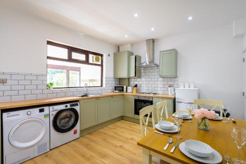 a kitchen with a table and a washing machine at Beautiful 2 Bedroom House in Atherton, Free Parking in Atherton